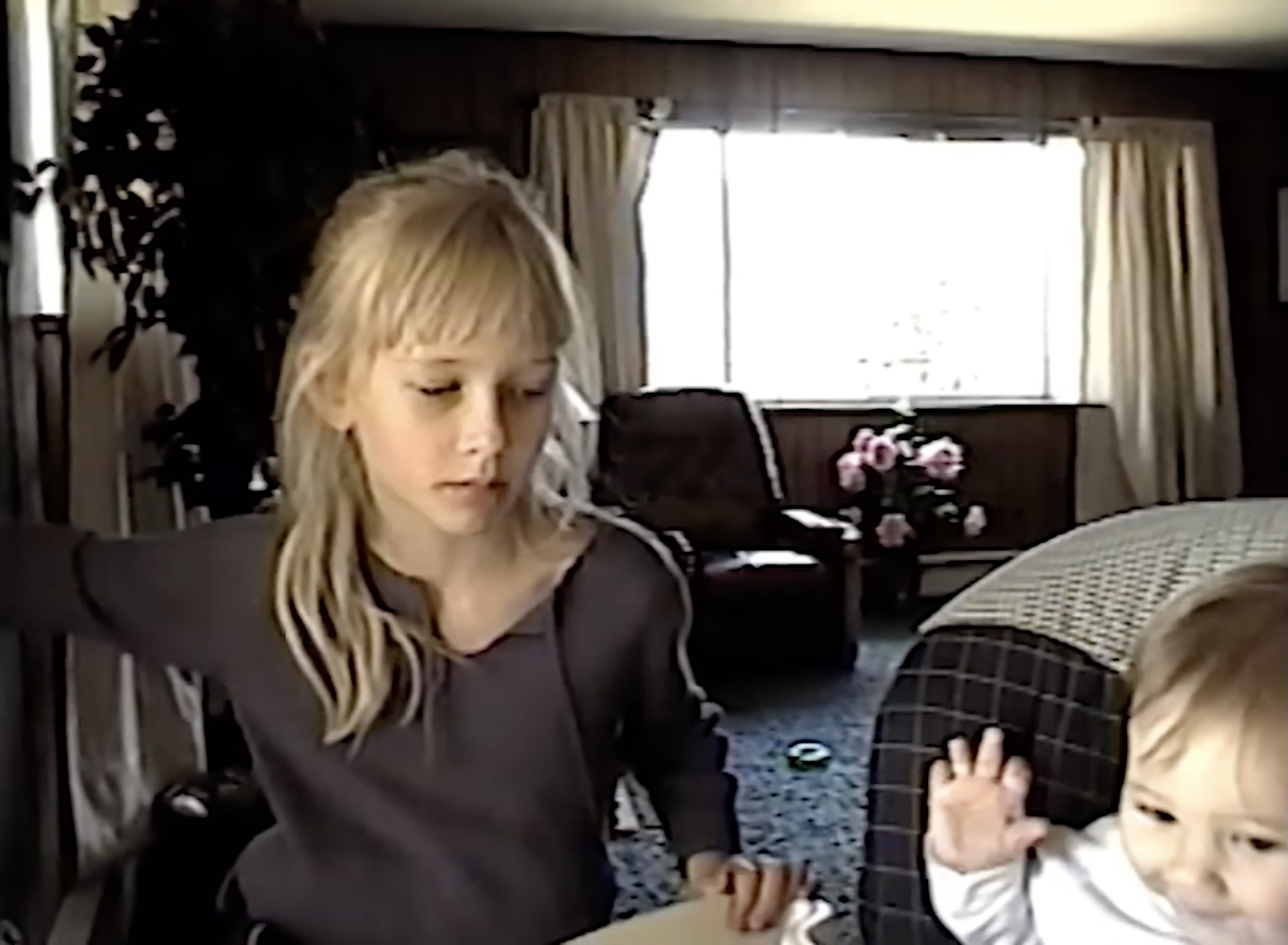 Akiane in a living room beside her baby brother