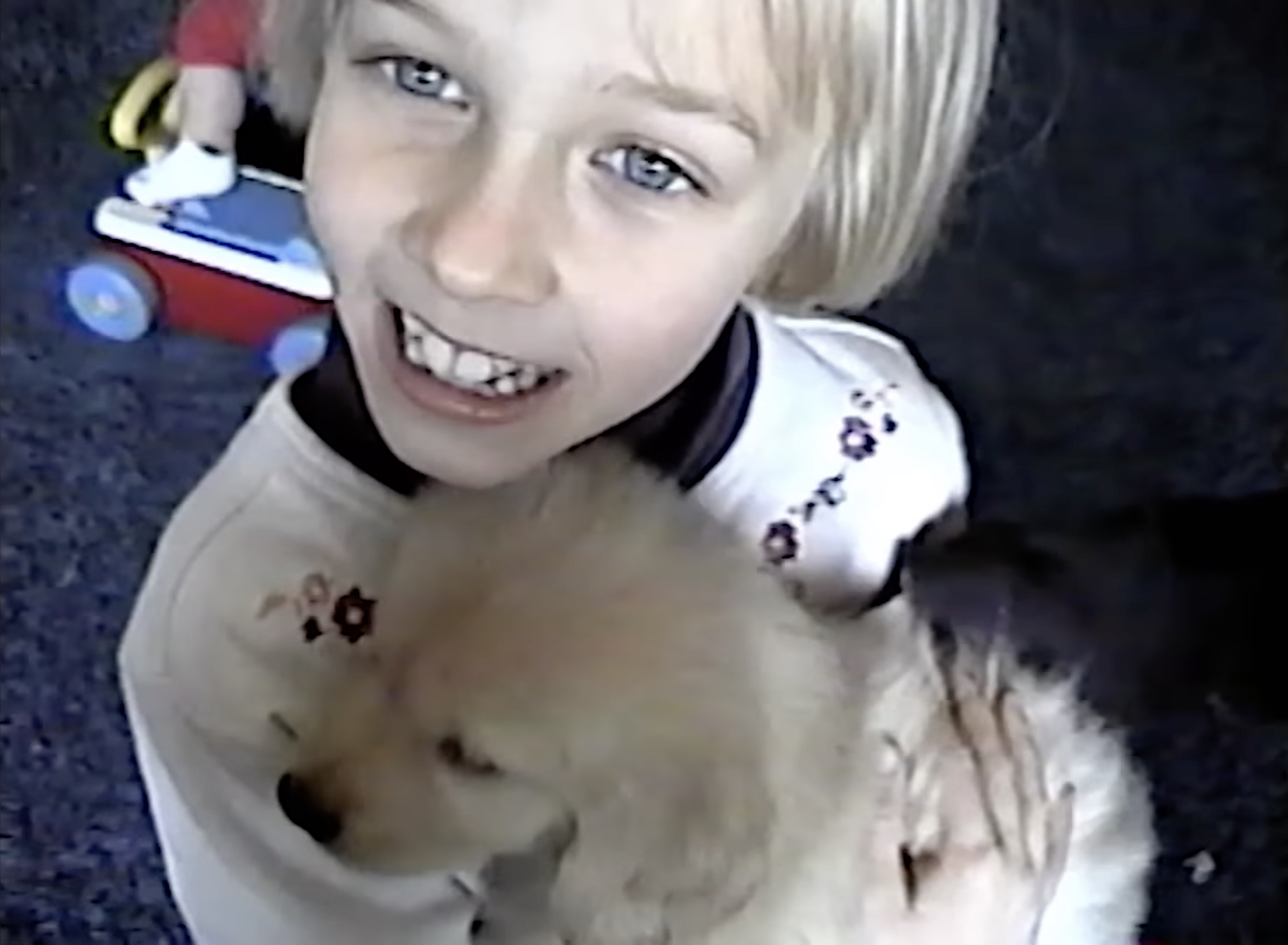 Akiane smiling, holding a fluffy puppy