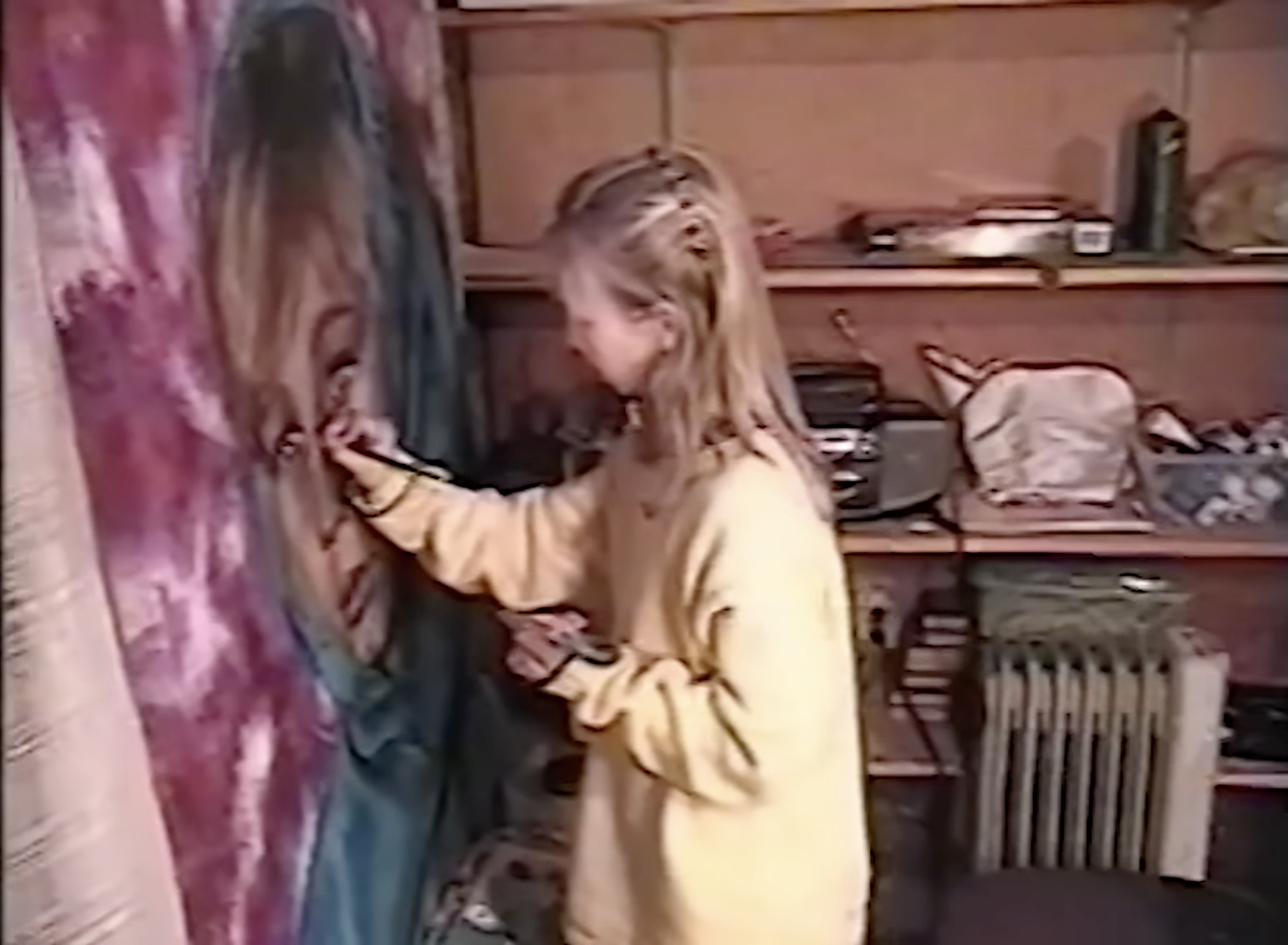 Young Akiane painting a large face in purples and blues