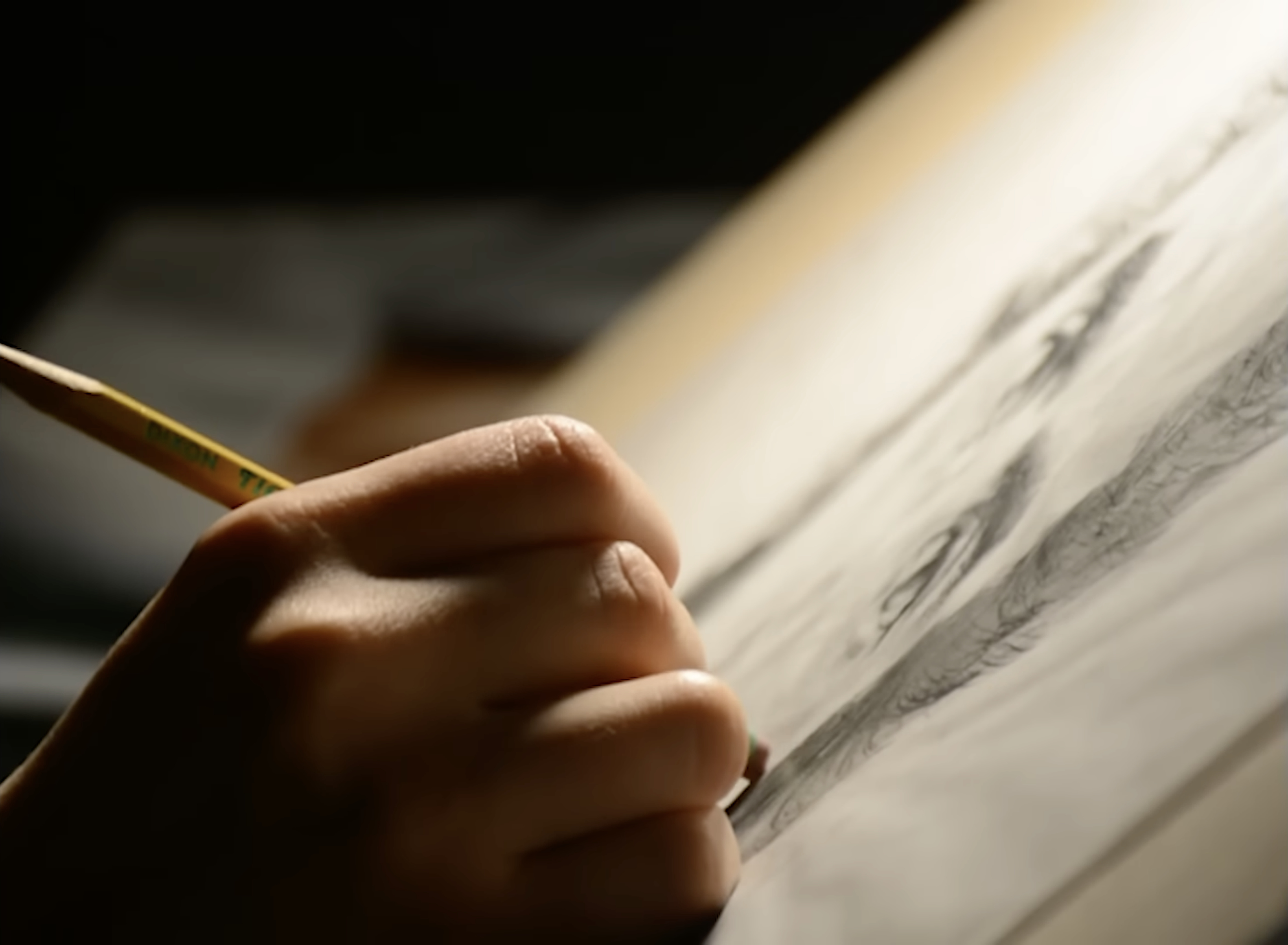 Close-up of a hand pressing a pencil to paper