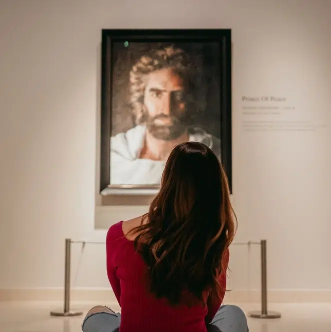 A visitor seated before Akiane Kramarik's Prince of Peace