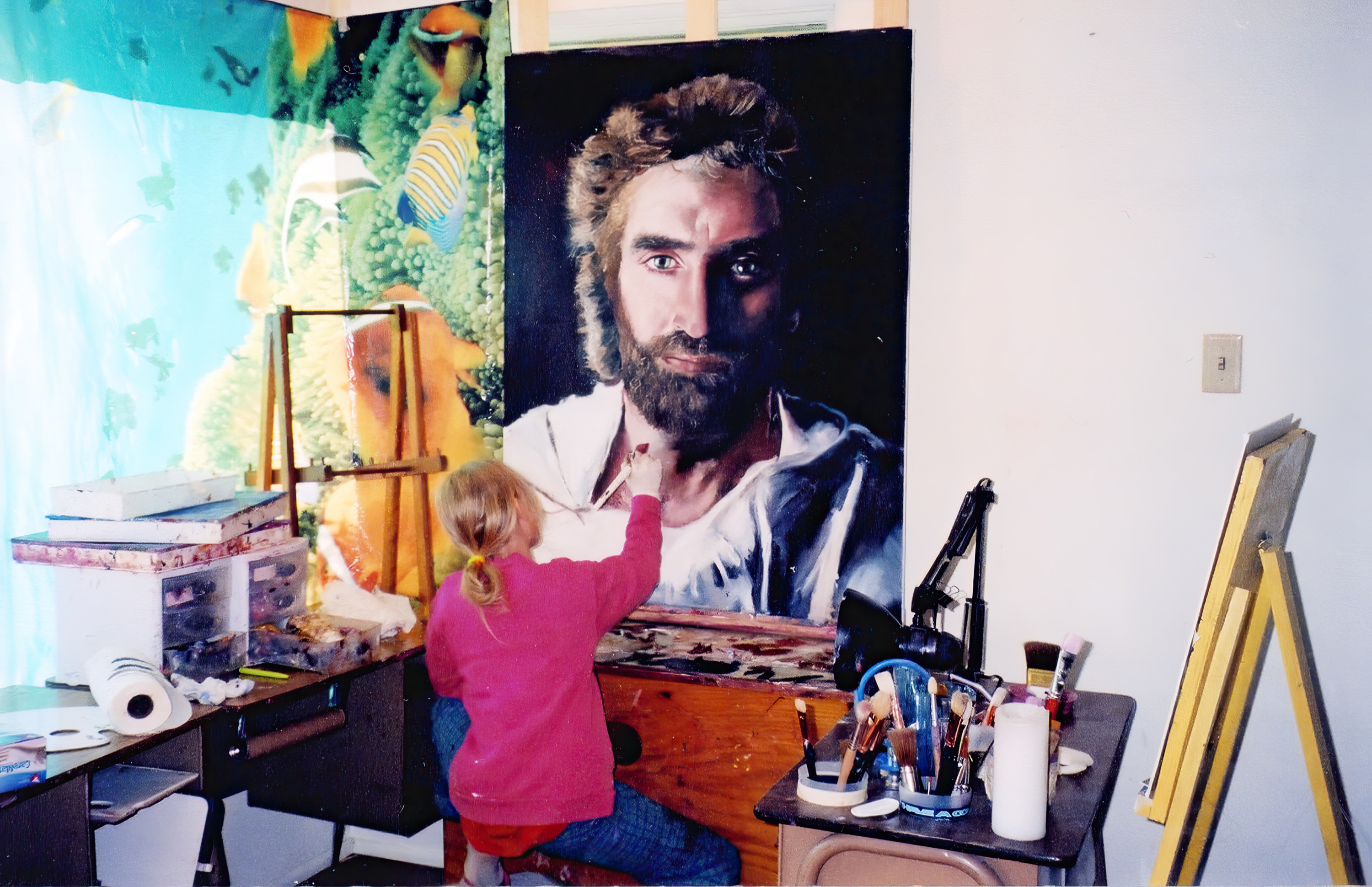 Young Akiane on a stool painting the collar of the nearly finished portrait